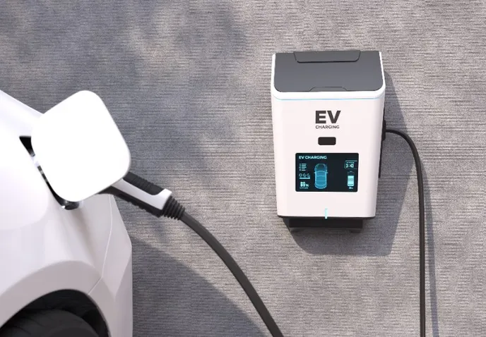 A white electric car plugged into a wall-mounted EV charging unit