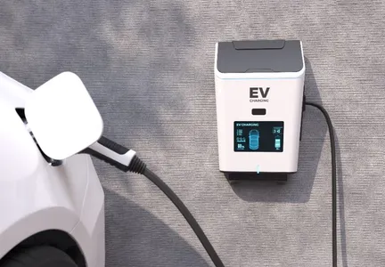 A white electric car plugged into a wall-mounted EV charging unit