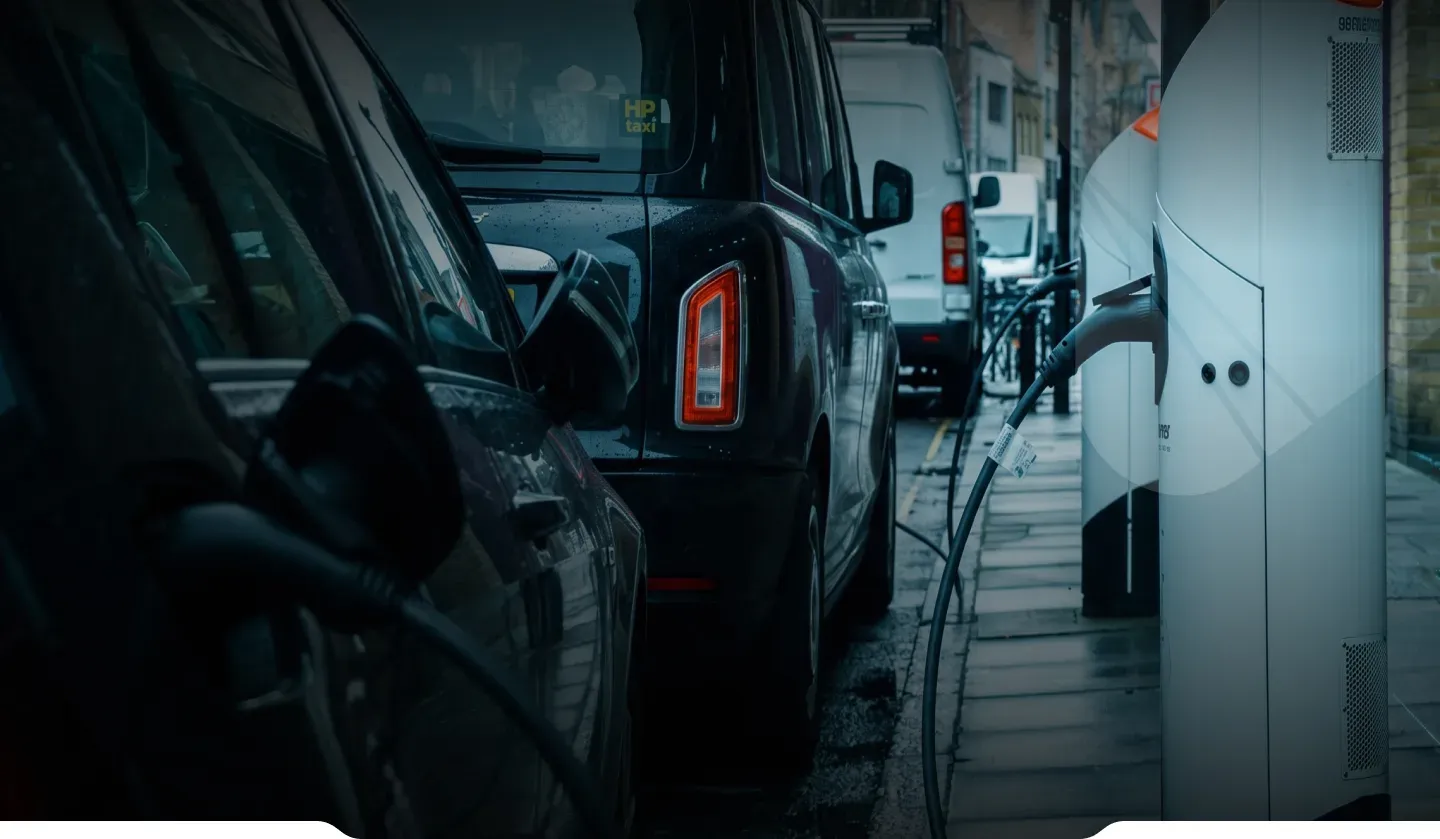 Electric vehicles plugged in at a row of public chargers