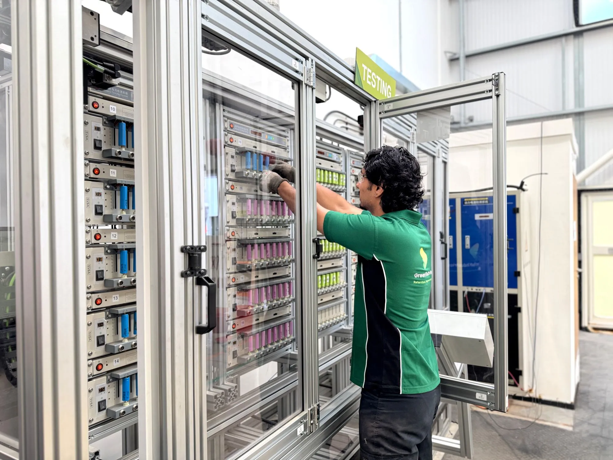 A GTI technician loading cylindrical cells into a battery testing rack