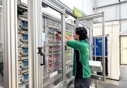 A GTI technician loading cylindrical cells into a battery testing rack
