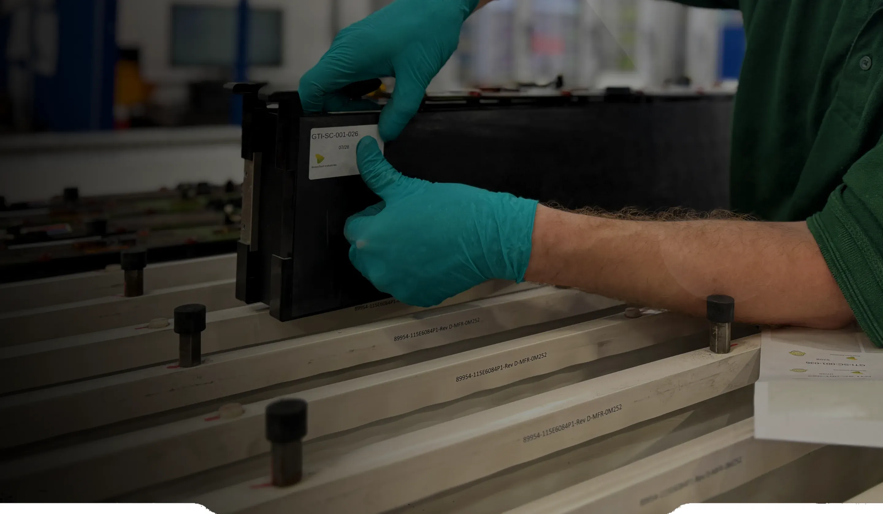 A GTI technician in blue gloves labelling a battery module recovered from an open pack