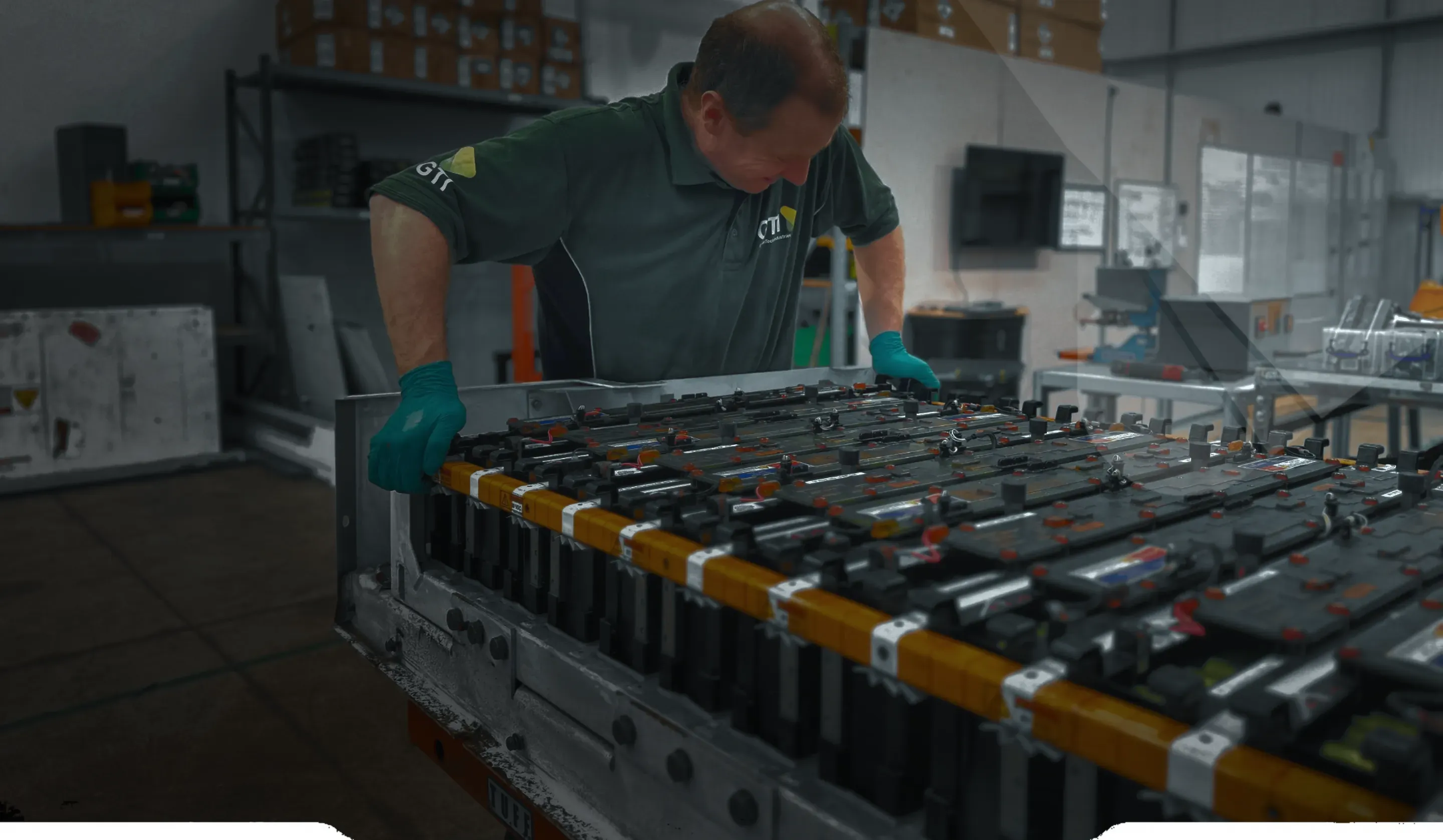 A GTI technician working over an opened high-voltage battery pack