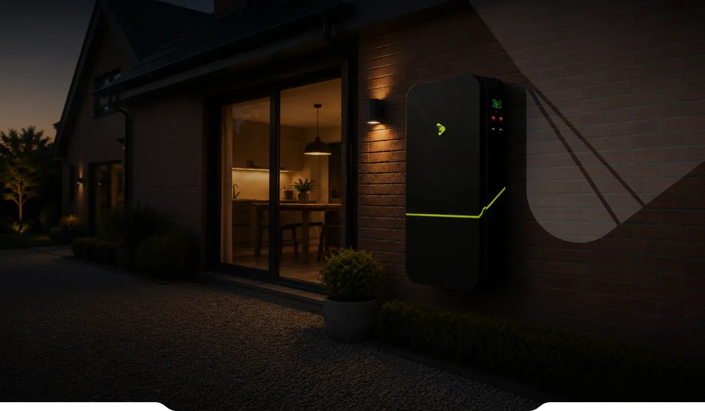 A home battery storage unit mounted on an exterior house wall at dusk
